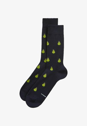 Sorte crewsokker med et gentaget mønster af små grønne Grinch-ansigtet hele vejen igennem.