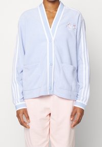 Light blue fleece cardigan with white accents, v-neck, button closure, two front pockets, and floral logo embroidery on the chest.