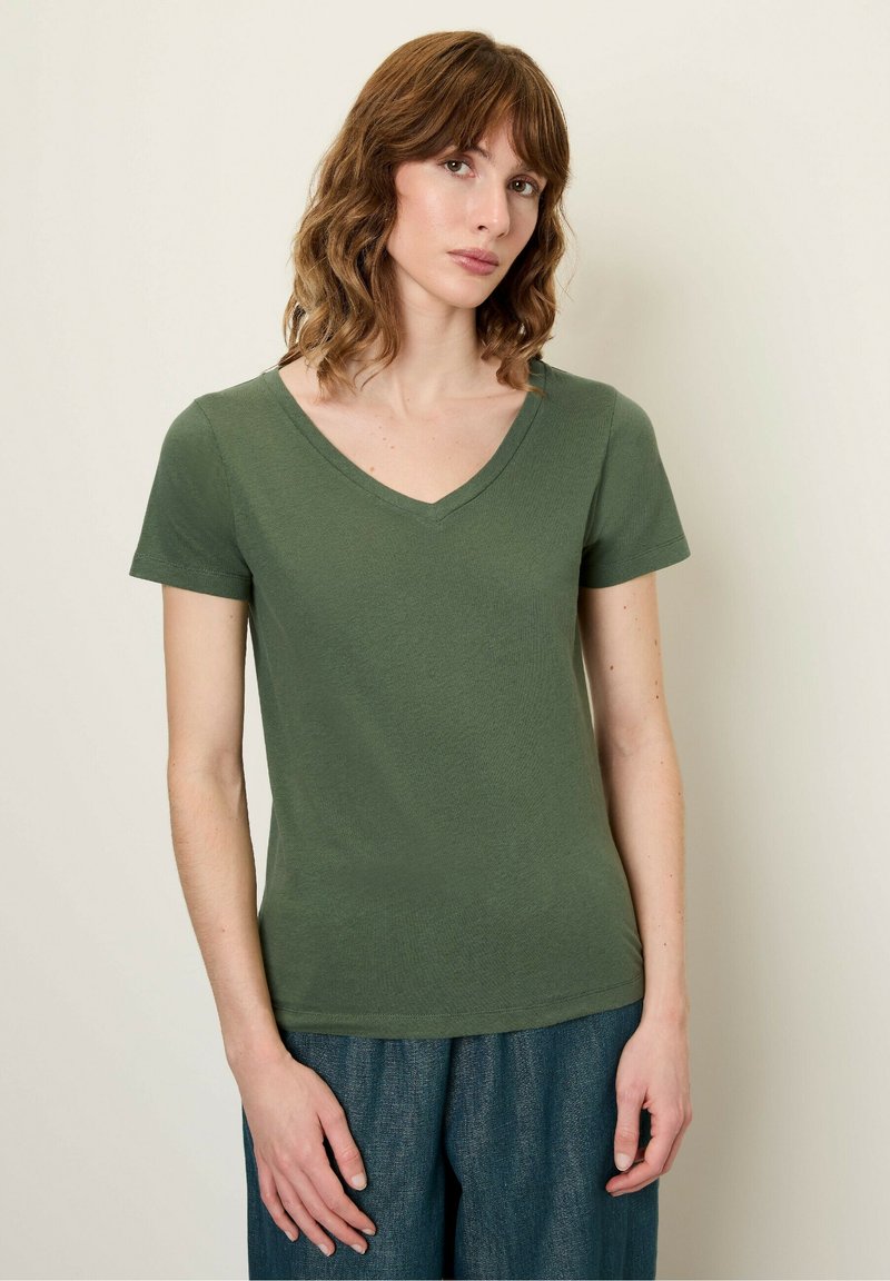 T-shirt verde oliva a maniche corte con scollatura a V, realizzato in tessuto morbido. Presenta una forma aderente e una texture liscia.