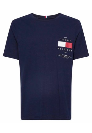 Marineblaue T-Shirt mit Rundhalsausschnitt und kurzen Ärmeln, das ein kleines Tommy Hilfiger-Logo sowie eine rot-weiße-blau Flagge auf der Brust zeigt.