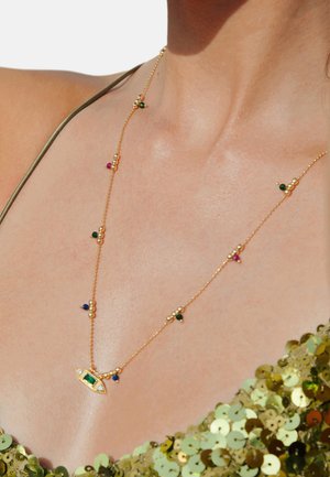 Collier en or avec un pendentif en forme d'œil, comportant une pierre verte centrale entourée de perles colorées. Design de chaîne délicate, surface texturée.