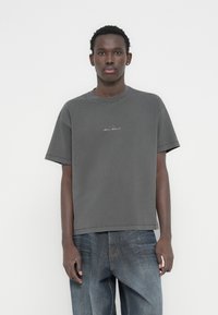 Heather γκρι κοντομάνικη μπλούζα με στρογγυλή λαιμόκοψη, διακοσμητική ραφή και διακριτικό λογότυπο στο στήθος. Κατασκευασμένη από μαλακό ύφασμα.