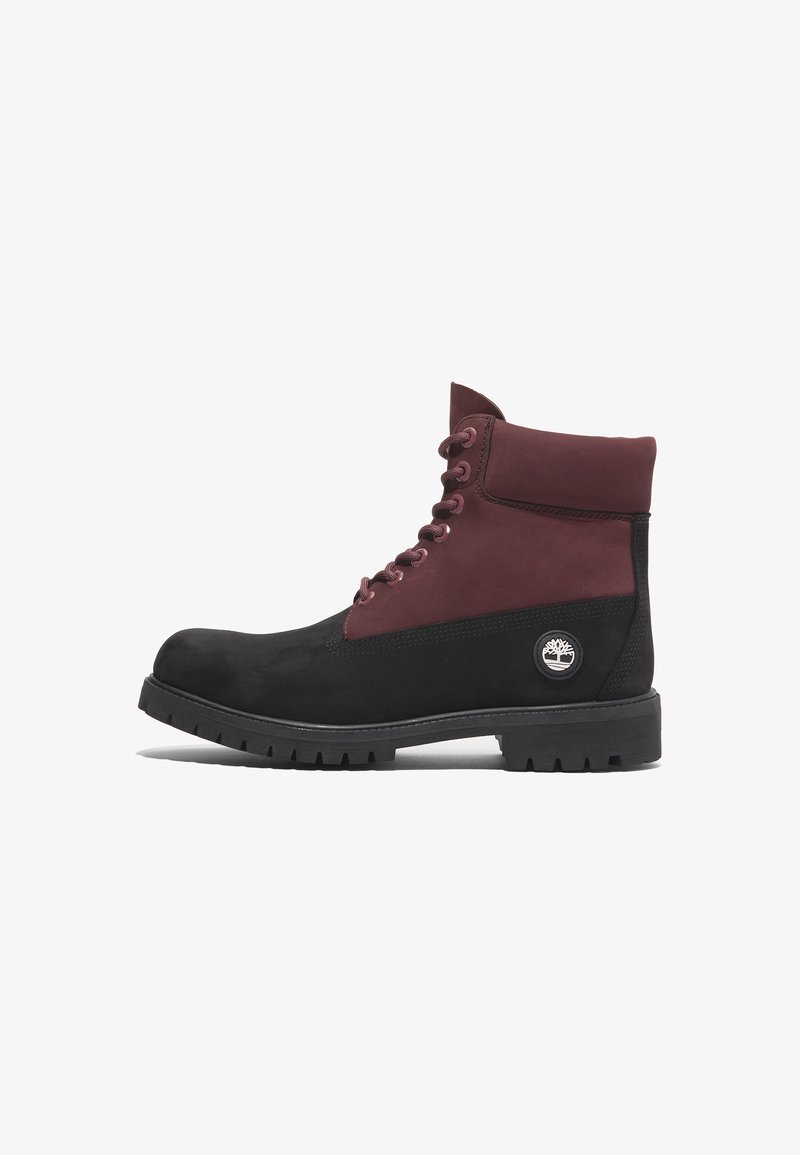 Botas de tobillo en negro y burdeos con textura de ante, punta redonda, cuello acolchado y suela de goma con un patrón de tacos.