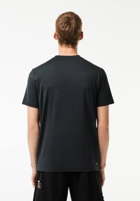 T-shirt corto a maniche corte grigio scuro, colletto a girocollo, texture liscia, vestibilità comoda, realizzato in misto cotone, con un piccolo logo sul lato inferiore.