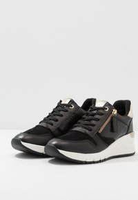 Schwarze und goldene Sneaker mit einer Kombination aus glattem Leder und strukturierten Akzenten, Schnürdesign und einer weißen Keilsohle.