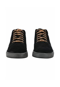 Une paire de chaussures en suède noir avec des lacets beiges et des semelles en caoutchouc grises, présentée de face sur un fond blanc.