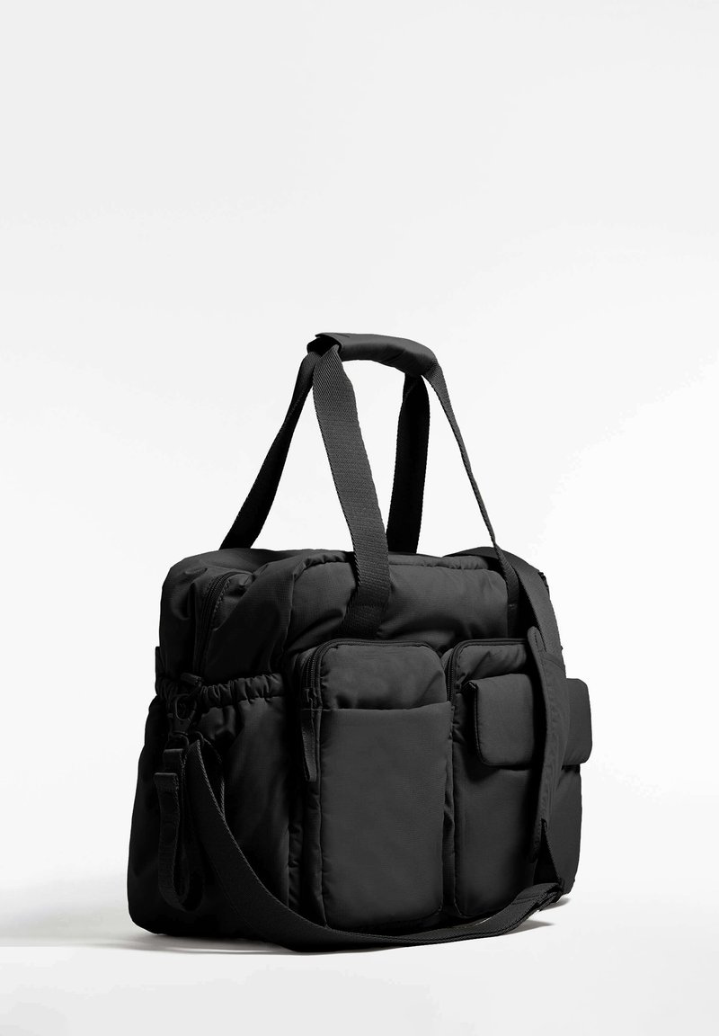 Borsa a mano nera con design trapuntato, molteplici tasche con zip e a fessura, doppi manici superiori e tracolla removibile.