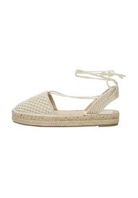 Sandale espadrille tissée en beige avec une semelle en jute tressé, talon ouvert, liens de cheville et partie supérieure texturée présentant un motif géométrique.