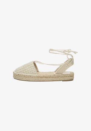 Sandale espadrille tissée en beige avec une semelle en jute tressé, talon ouvert, liens de cheville et partie supérieure texturée présentant un motif géométrique.