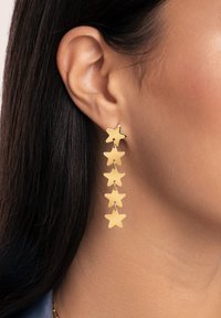 Pendientes en forma de estrella dorada con un diseño en cascada que presenta cinco estrellas enlazadas, acabado pulido y herrajes minimalistas.