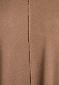 Ruda megzta audinys su lygiu paviršiumi, viduryje vertikaliai einanti siūlė. Matomi jokie raštai ar metalinės detalės.