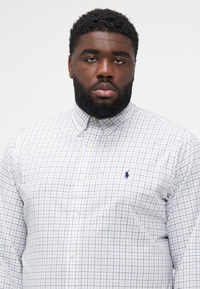 Chemise à boutons avec une base blanche ornée d'un motif à carreaux bleu marine, manches longues, col et petit logo brodé sur la poitrine.