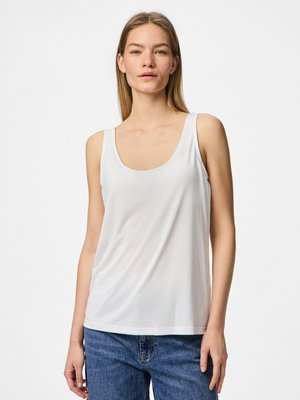 Witte mouwloze tanktop van een gladde, lichte stof met een ronde hals. Gecombineerd met hooghangende blauwe spijkerbroeken.