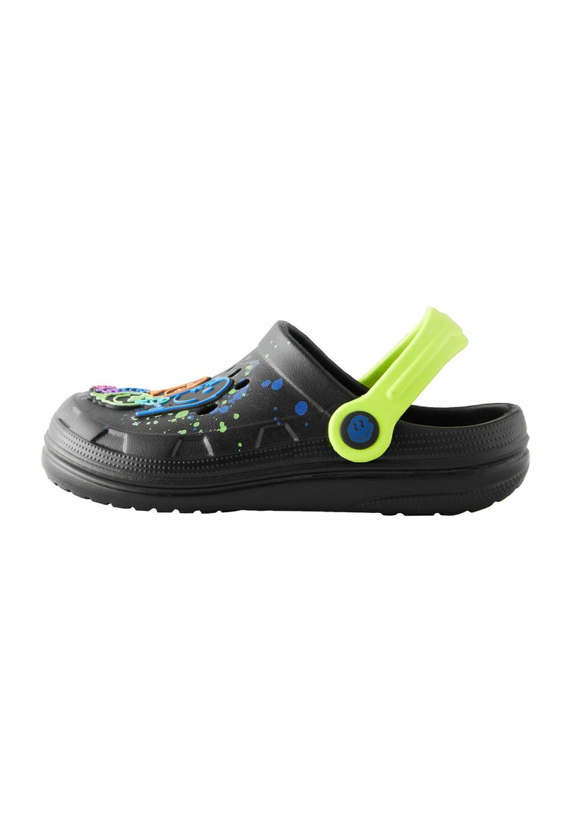 Schwarzer Gummischuh mit buntem Spritzmuster, einem blauen kreisförmigen Akzent und einem leuchtend grünen Riemen auf der Rückseite. Leichtgewichtig, schlüpfendes Design.