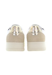 Vita sneakers med en beige mocka-häl och metallisk guldakcent. Har embossad text "SINCE 1890" på hälen. Slimmad, sportig design.