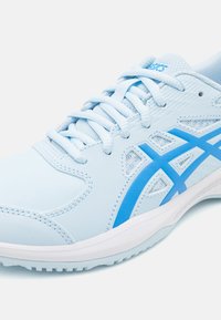 Săptămână sportivă de culoare albastră deschisă cu talpă albă, având un superior sintetic neted, accente din plasă și un element de design din plastic albastru.
