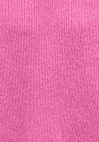 Pletena tkanina v enobarvni, svetlo roza barvi z gladko teksturo in enakomernim vzorcem majhnih šivov po celotni površini.