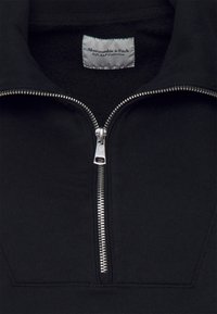 Černý fleecový pulovr na zip s vysokým límcem, stříbrným zipem a měkkým interiérem. Štítek uvádí "Abercrombie & Fitch Soft A&F Collection."