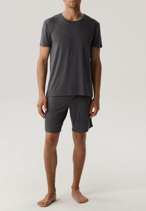 Szary bawełniany t-shirt z krótkim rękawem w zestawie z pasującymi szortami. Oba elementy są gładkie, dopasowane i mają okrągły dekolt oraz bezszwowy design.