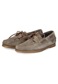 Scarpe da barca in suede grigio con profilo basso, punta arrotondata, lacci in pelle marrone, occhielli dorati e dettagli cuciti lungo i lati.