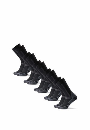 Otto paia di calzini neri da uomo con talloni e punte grigi, disposti in due file diagonali ordinate su uno sfondo bianco.