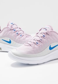 Ljust lila mesh-sneakers med vita och ljusgrå accenter, med blå Nike-logotyp och "MAX AIR"-text på sidan.