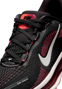 Scarpa da corsa nera con tomaia in mesh, dettagli rossi e il logo Nike in argento. Presenta un colletto imbottito e lacci per una vestibilità sicura.