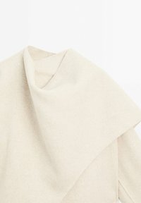 Tissu couleur crème avec une surface douce et texturée, présentant des plis superposés et un design drapé. Apparence minimaliste et légère.