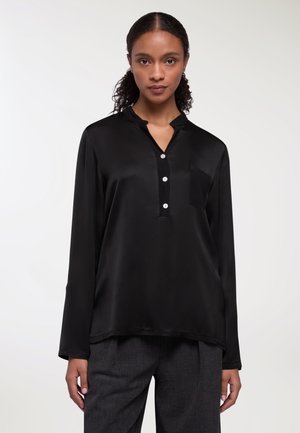 Camicia nera in satin a maniche lunghe con colletto a punta, tre bottoni e taschino sul lato sinistro del petto. Tessuto liscio e vestibilità comoda.