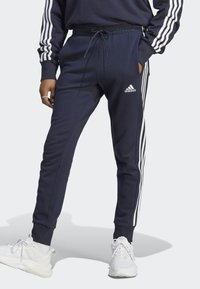 adidas Sportswear - ESSENTIALS FRENCH TERRY TAPERED CUFF 3 STRIPES PANTS - Spodnji deli trenirk - legend ink/white Miniaturna slika 1