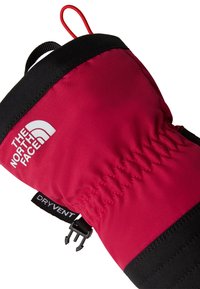 Rdeča nepremočljiva rokavica s črnimi poudarki, elastičnim šivanjem, logotipom na zgornji strani in zaponko za pritrjevanje s sponko.