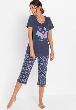 Ensemble de pyjama marine avec un motif de papillons. Le haut à manches courtes présente un graphique en rose et turquoise. Le pantalon court arbore un motif de papillons multicolores.