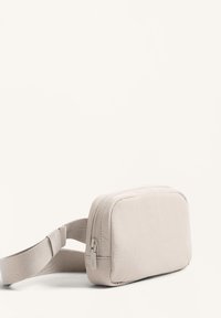 Borsa a pochette rettangolare beige chiaro con finitura testurizzata, dotata di chiusura con cerniera e tracolla regolabile. Design compatto e minimalista.