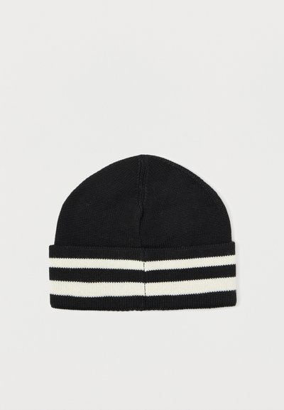 Gorro de punto negro con un dobladillo, que presenta tres rayas horizontales blancas. El material parece suave con un tejido apretado y una parte superior redondeada.
