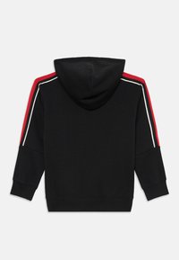 Sweatshirt preto com um detalhe listrado em vermelho e branco em cada manga, feito de tecido macio, com um bolso canguru e capuz com cordão ajustável.