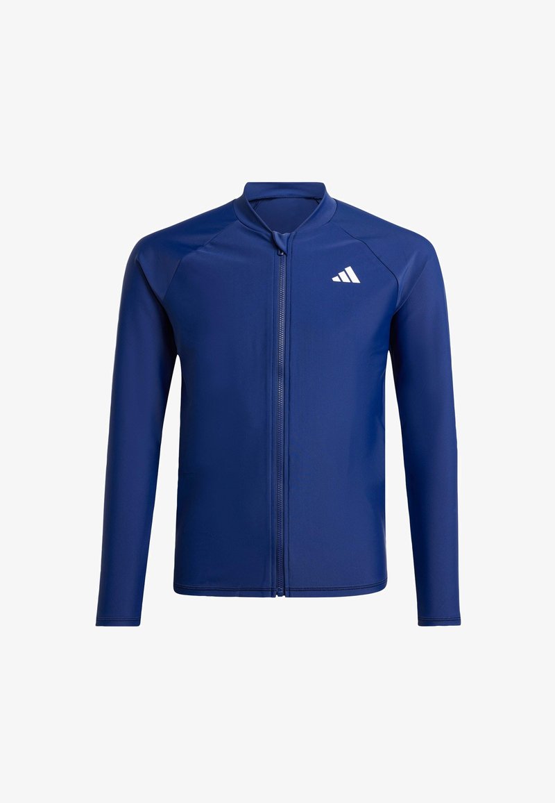 Marineblå idrettsjakke med lange ermer, høy krage, hel glidelås foran og en hvit logo på venstre bryst. Glatt, elastisk tekstur.