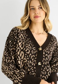 Brown and beige leopard print cardigan with a v-neck, three gold buttons, and ribbed cuffs for texture and warmth.