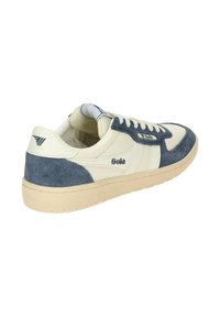 White and navy blue sneakers with a suede and leather combination, featuring a textured sole and branded accents. Rounded toe design.