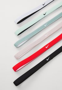 Sei elastici per capelli di vari colori: bianco, verde acqua, rosa chiaro, rosso e nero, con accenti di logo discreti su alcuni elastici.