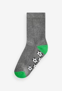 Graue Socke mit grünem Fersen- und Zehenbereich, die ein Muster aus weißen und schwarzen Fußballen an der Seite zeigt. Aus einem weichen, strukturierten Stoff gefertigt.