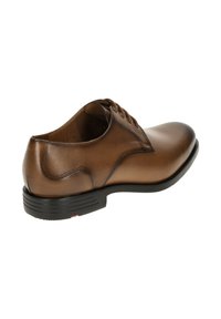 Chaussure habillée en cuir marron avec une finition lisse, un bout arrondi et un design à lacets. Dotée d'une semelle en caoutchouc noire et de détails de couture subtils.