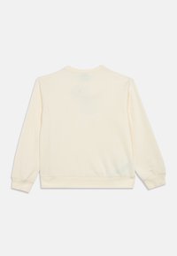 Κρεμ μπλούζα με μακριά μανίκια, στρογγυλή λαιμόκοψη και ριμπ μανσέτες και στρίφωμα. Φτιαγμένη από μαλακό, υφή υλικό.