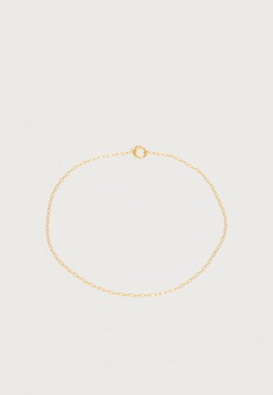 Collier délicat en chaîne d'or avec un petit fermoir circulaire sur un fond blanc uni.