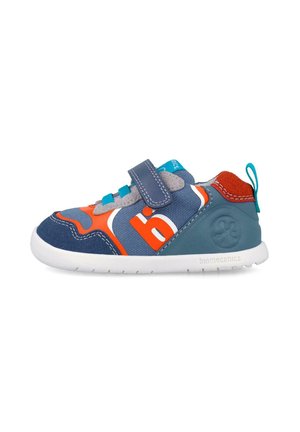 Zapatilla infantil azul, naranja y gris con cierre de velcro, parte superior textil y sintética, y suela blanca flexible.