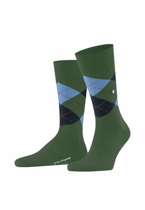 Grüne Socken mit einem Rautenmuster in Blau, Dunkelblau und Grün, ergänzt durch rote Akzente am Bündchen und das Markenlogo auf der Sohle.