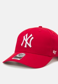 Rød baseballkasket med et fremtrædende hvidt broderet NY-logo frontpå, designet med en ensfarvet farve og en struktureret krone.