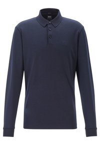 Navy pitkähihaista polo puseroa, joka on valmistettu sileästä kankaasta. Siinä on kauluksen näköinen pääntie, kolmonen napitus edessä ja huomaamaton logo rinnassa.