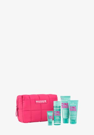 Rosa gesteppte Kosmetiktasche von Nuxe Paris mit vier türkisfarbenen Tuben und Flaschen der Hautpflegeprodukte Zinc Power.