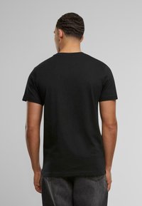 Svart bomull t-skjorte med korte ermer, enkel rund hals-design, glatt tekstur og ingen synlige mønstre eller logoer på baksiden.