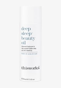 Hvit sylinderformet flaske merket "deep sleep beauty oil," 150 ml. Har turkise tekster og svart logo, designet for kroppspflege og hudens elastisitet.